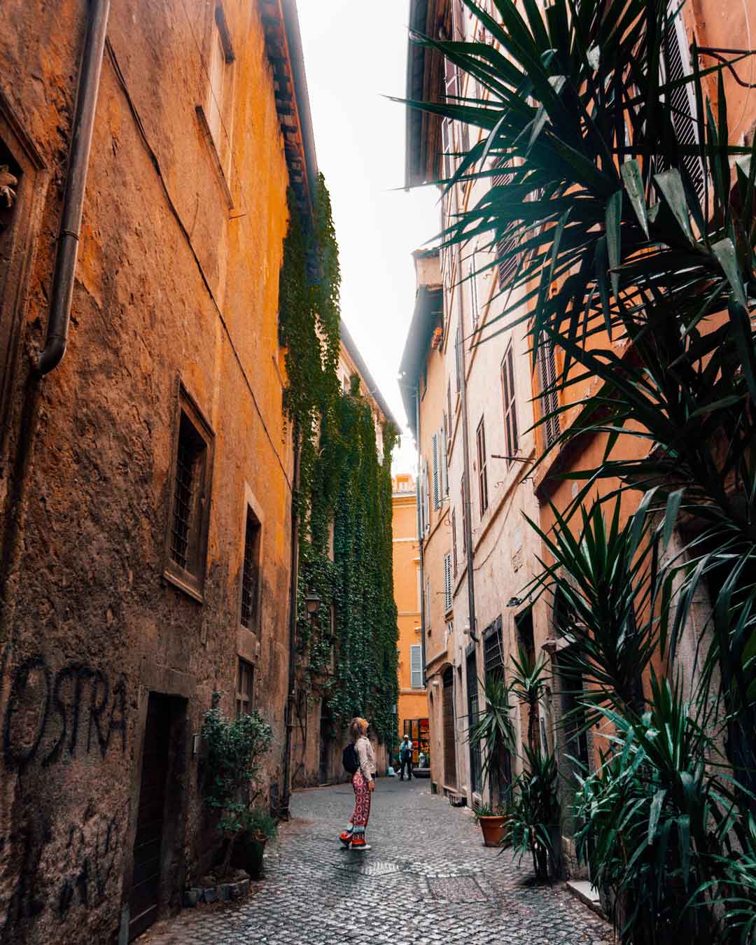 a woman standing in a narrow streets in rome