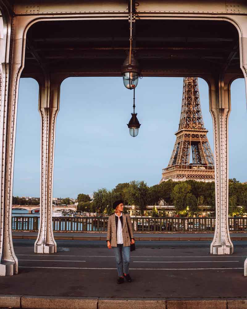 Woman standing on Bir-Hakeim bridge, with the Eiffel Tower in the background