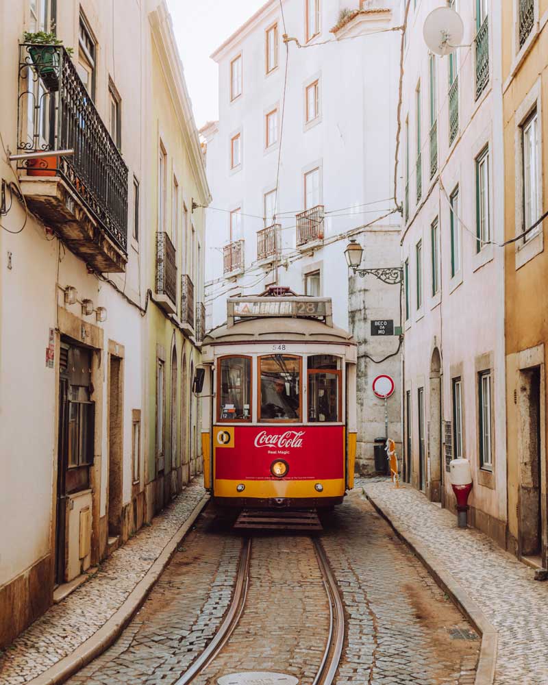 Yellow tram in narrow street in Lisbon